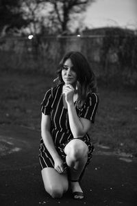 Young woman crouching on road