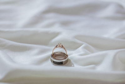 High angle view of wedding rings on bed