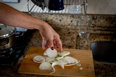 Hand holding sliced onions on a cutting board. food seasoning.