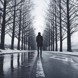 Rear view of man standing on road in winter