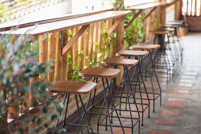 Empty stools by railing in restaurant
