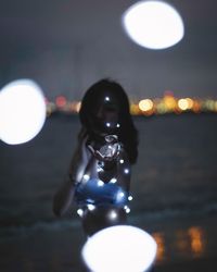 Close-up portrait of illuminated light bulb at night