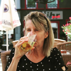 Portrait of woman drinking glass in restaurant