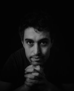 Close-up portrait of young man against black background