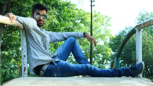 Portrait of man sitting on footbridge