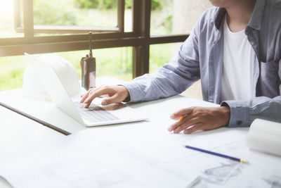 Midsection of man using laptop on table