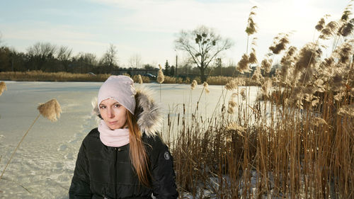 Portrait of woman standing against plants in winter