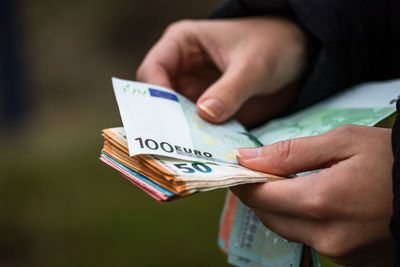 Midsection of person holding paper