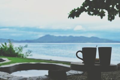 Close-up of table by sea against sky