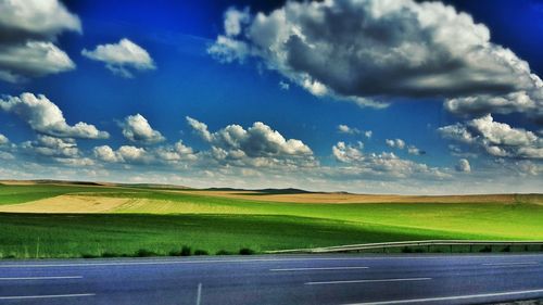 Scenic view of field against cloudy sky