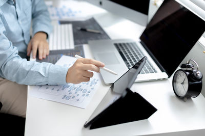 Midsection of businessman working on table