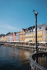 Buildings at waterfront against blue sky