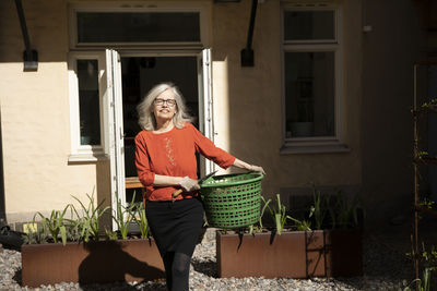 Smiling woman in front of house