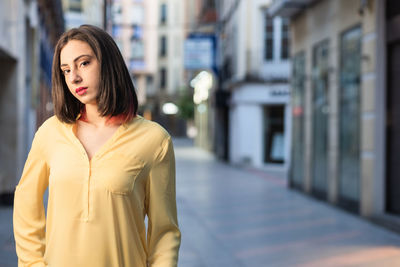 Portrait of beautiful woman standing in city