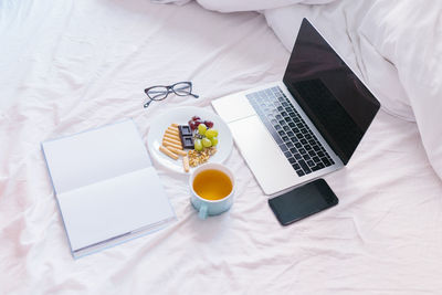 High angle view of coffee and laptop on table