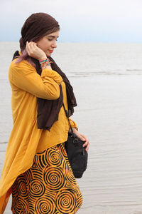 Young woman standing at beach