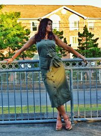 Full length of young woman standing by railing