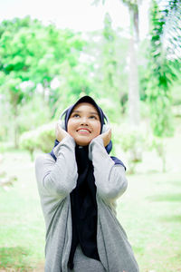 Portrait of smiling young woman standing outdoors