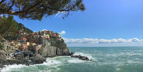 Scenic view of sea by cliff against sky