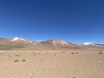 Scenic view of desert against clear blue sky