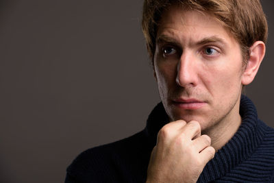 Close-up portrait of young man against black background