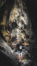 Low angle view of woman on rock formation in cave