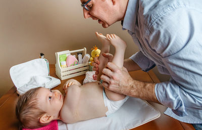 Father changing diaper of daughter