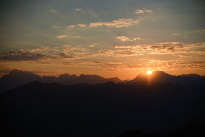 Scenic view of silhouette mountains against sky at sunset