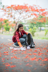 Full length of woman with orange leaves during autumn