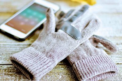 Close-up of gloves and smart phone on table