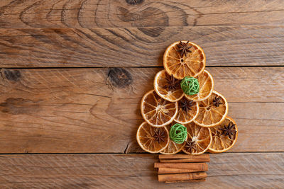 Christmas tree made of dried oranges, cinnamon and star anise on wooden background. copy space 