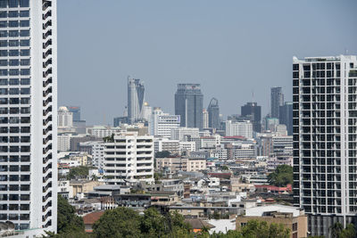 Buildings in city against clear sky