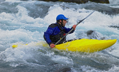 Man going on his white water kayak rapids in an icelandic river