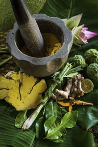 High angle view of fresh spices with mortar and pastel