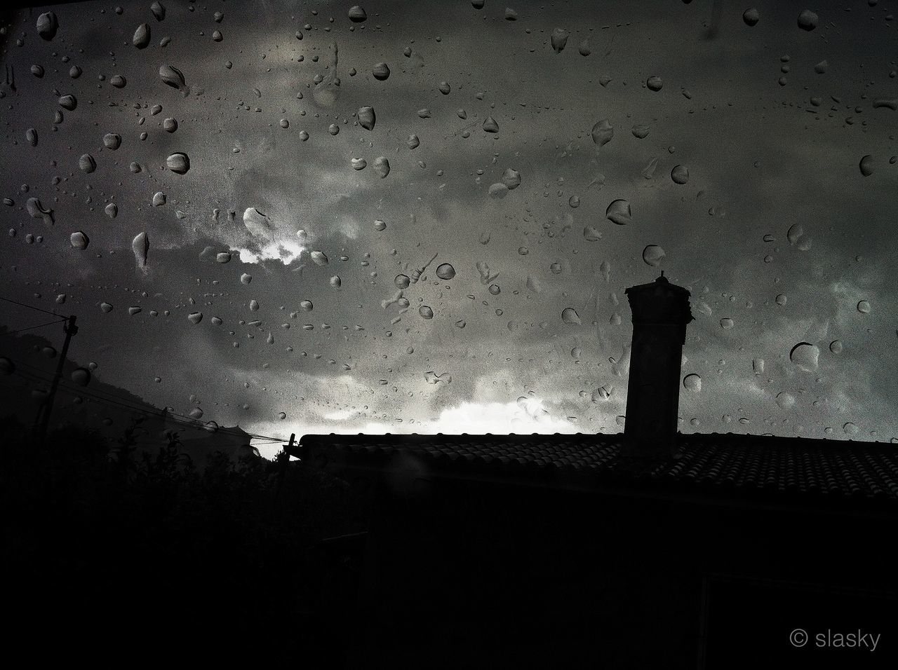 wet, rain, water, silhouette, built structure, architecture, window, building exterior, weather, drop, indoors, sky, dusk, street, high angle view, day, dark, shadow, glass - material