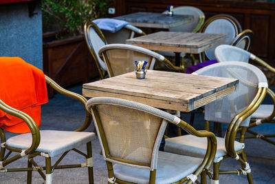 Empty chairs and tables at sidewalk cafe