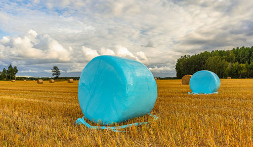 Hay bales that are wrapped in plastic, the bales come in all possible colors.