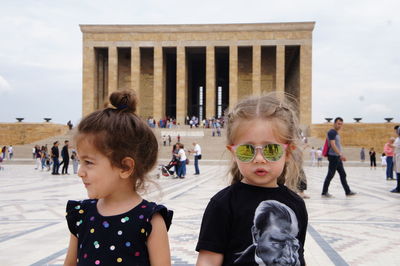 Sisters standing in front of built structure