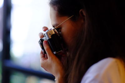 Close-up of woman photographing indoors