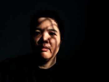 Close-up portrait of woman in darkroom