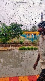 Raindrops on windshield seen through wet window