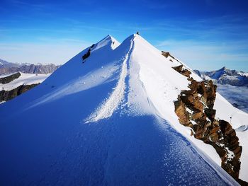 Snow covered mountain against blue sky