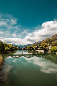 Arch bridge over lake against sky