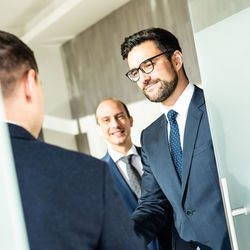 Group of confident business people greeting with a handshake at business meeting in modern office or