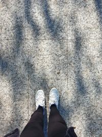 Low section of person standing on footpath