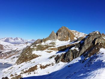 Scenic view of snowcapped mountains against clear blue sky