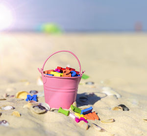 Close-up of multi colored letters in bucket at beach