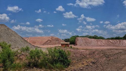 Built structure on landscape against cloudy sky