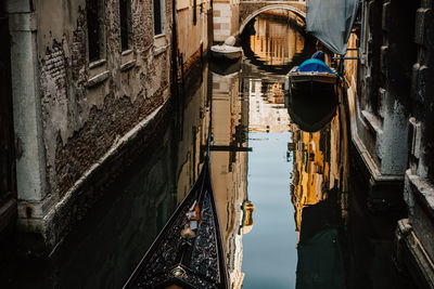 Gondola sailing on canal amid buildings