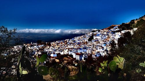 Aerial view of town by sea against sky